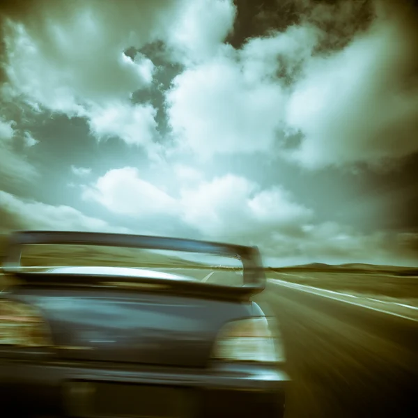 O carro correndo na estrada.com o fundo do céu nublado . — Fotografia de Stock