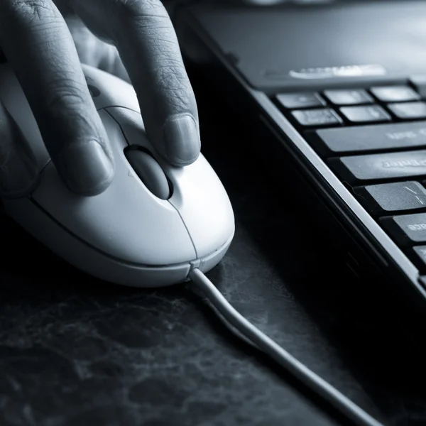 Homem usando o mouse de um laptop no prédio de escritórios . — Fotografia de Stock