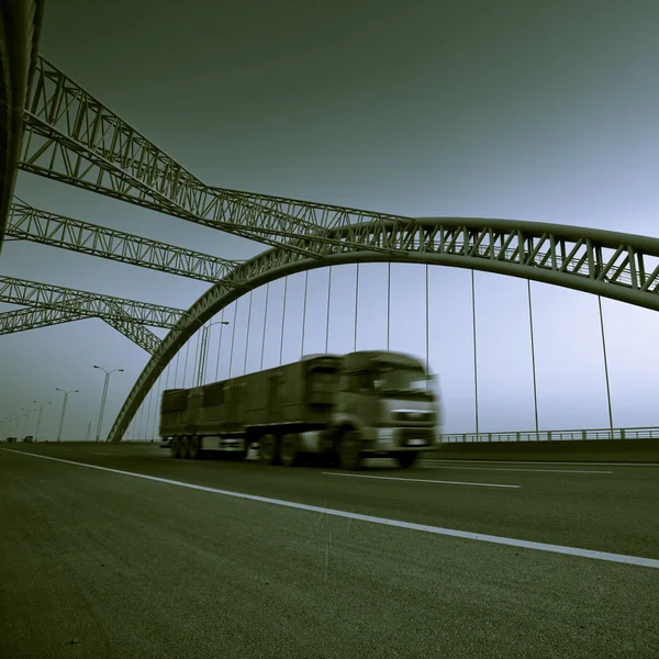 stock image Truck speeding through a bridge at sunset,motion blur.