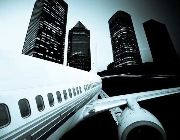 L'aeroplano lontano dalla città, sfondo astratto — Foto Stock