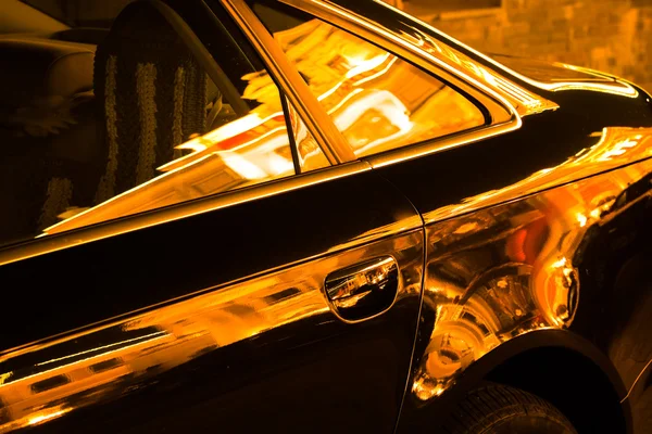 La luz de la noche se refleja en el cristal de las ventanas de un coche . — Foto de Stock