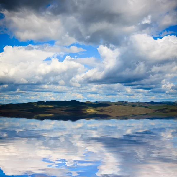 El fondo de la nube y su reflejo en el agua . — Foto de Stock