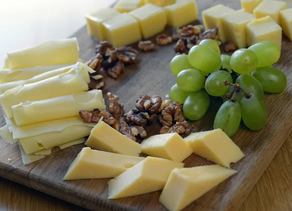 Käse auf ein Holzbrett setzen — Stockfoto