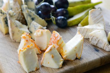 Set of cheese with mold on a wooden board clipart