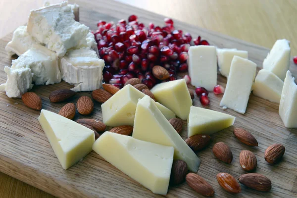 Conjunto de queso de cabra en una tabla de madera — Foto de Stock