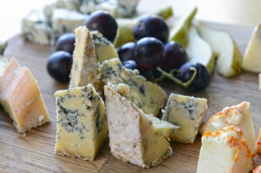 Set of cheese with mold on a wooden board clipart