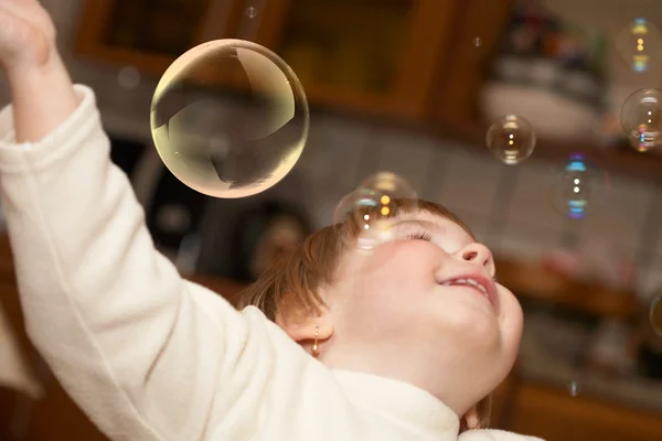 Het kleine meisje speelt met zeepbellen — Stockfoto