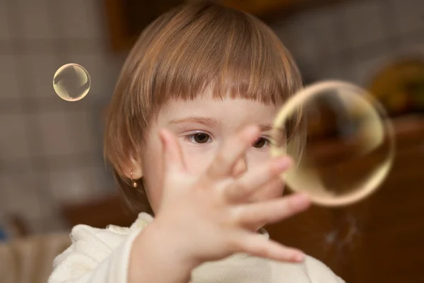 A menina pequena brinca com bolhas de sabão — Fotografia de Stock