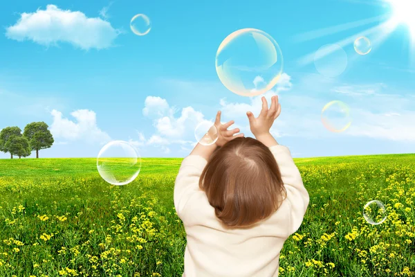 Den små flickan spelar med såpbubblor — Stockfoto