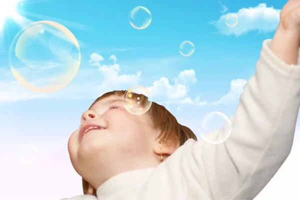 The small girl plays with soap bubbles — Stock Photo, Image