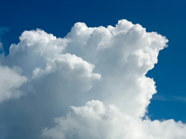 Weiße Kumuluswolke über dunkelblauem Himmel — Stockfoto