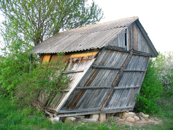 Verlaten oude houten klein gebogen huis — Stockfoto