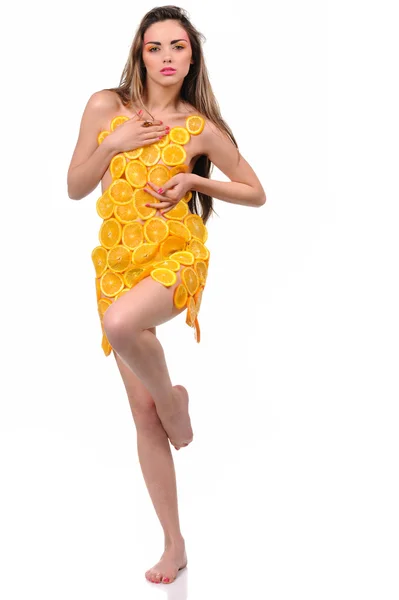 Νέα σέξι γυναίκα στο φόρεμα γίνεται από πορτοκαλί φρούτα — Φωτογραφία Αρχείου