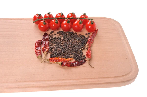 Black pepper red pepper and tomato on the wooden cutting board — Stock Photo, Image