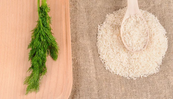 Rice with dill and spoon on the canvas — Stock Photo, Image