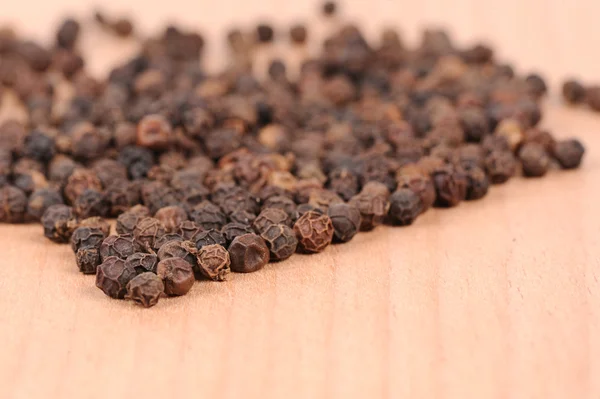 stock image Black pepper on the wooden cutting board