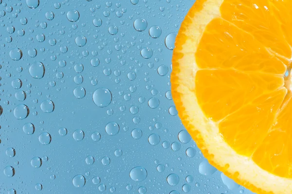 Orange mit vielen Wassertropfen auf blauem Hintergrund — Stockfoto