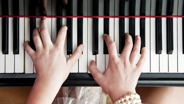 Händer på pianotangenter — Stockfoto