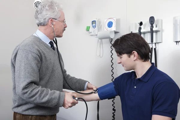 Доктор считывает частоту пульса пациента — стоковое фото