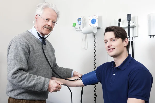 Доктор считывает частоту пульса пациента — стоковое фото
