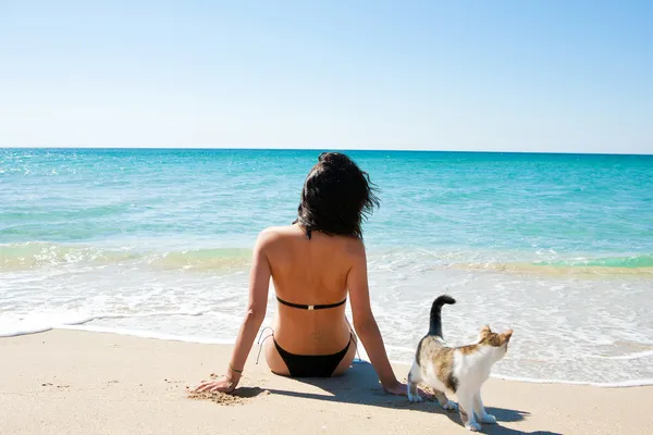Meisje op het strand met een kitten — Stockfoto