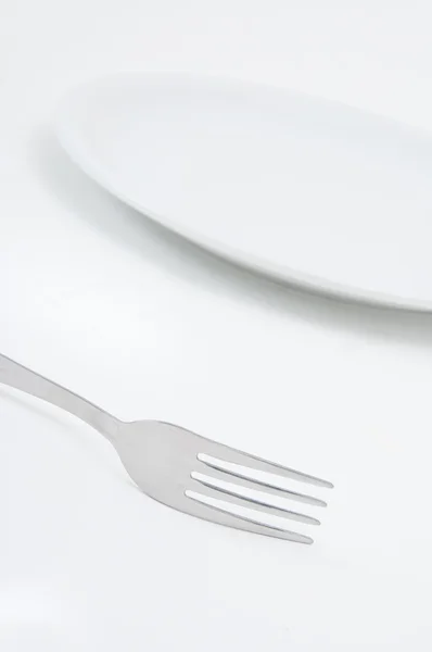 Metall gaffel och en tallrik — Stockfoto