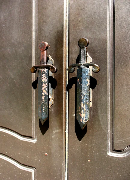 Een fragment van metalen deuren met handvatten in de vorm van dolken — Stockfoto