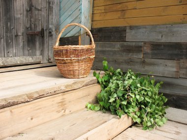 gesneden takken van berk en rieten mand op een houten veranda