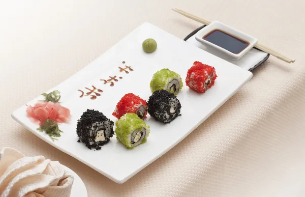 stock image Delicious sushi rolls on white plate with chopsticks and wasabi.