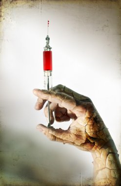 Old glass syringe in hand. Shallow DOF. clipart