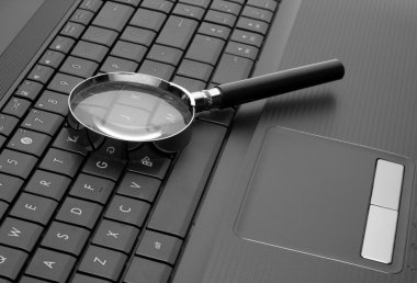 Magnifying glass on laptop clipart