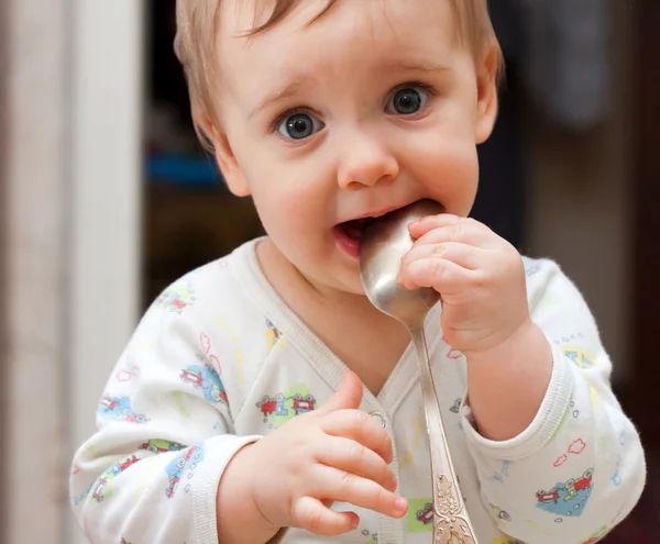 Bebé niña sosteniendo cuchara en la boca — Foto de Stock
