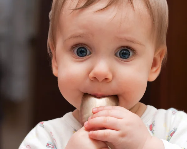 Baby girl holding spoon in mouth — Stock Photo, Image