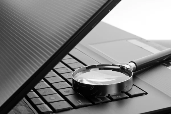 Magnifying glass on laptop computer — Stock Photo, Image