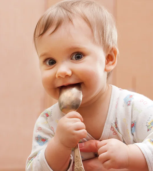 Feliz bebê menina segurando colher na boca — Fotografia de Stock