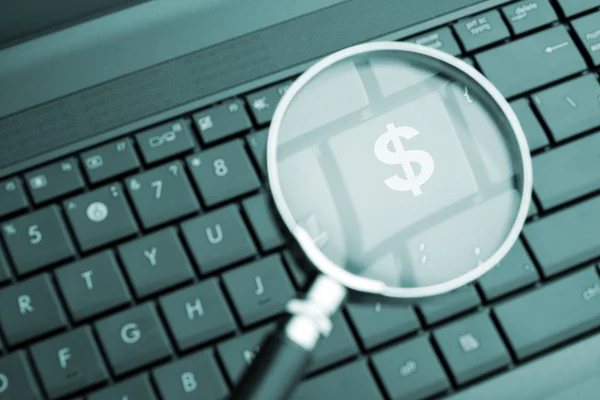 Magnifying glass focused on the $ button — Stock Photo, Image