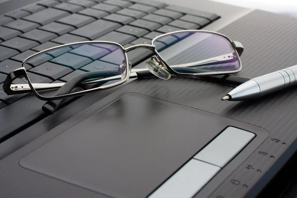 Brýle a pera na laptop — Stock fotografie
