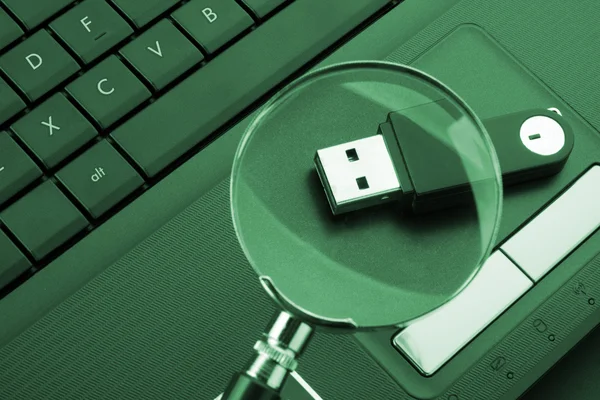 Magnifying glass focused on the flash drive — Stock Photo, Image