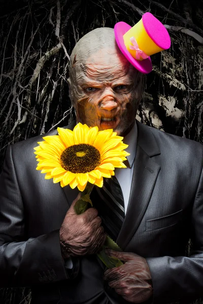 Sad business monster with sunflower — Stock Photo, Image