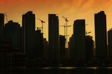 Silhouettes of buildings in Dubai at sunset clipart