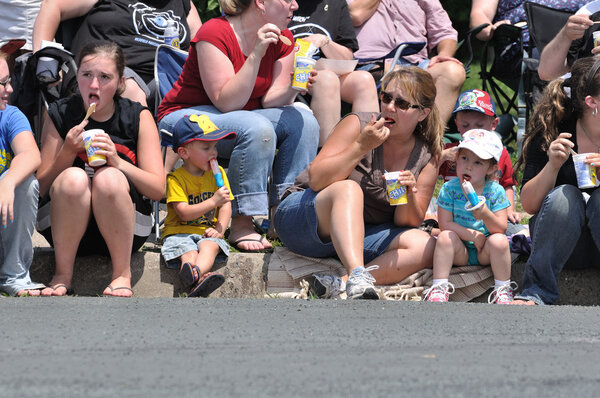 Family Eating Frozen Treats while Watching Parade
