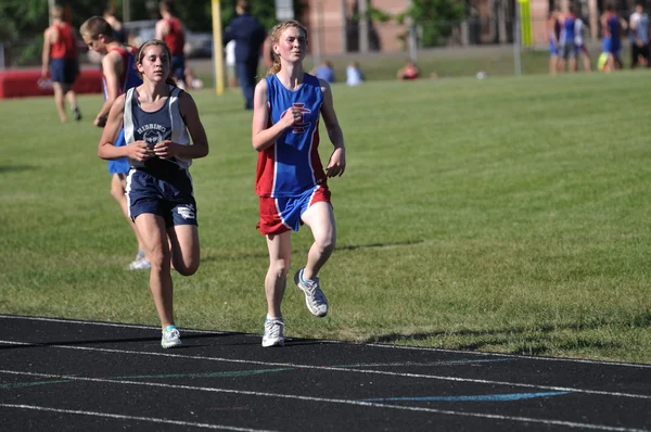 Teenager piger konkurrerer i lang afstand high school track møde race - Stock-foto