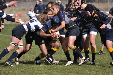 Player Being Tackled in a Women's College Rugby Match clipart