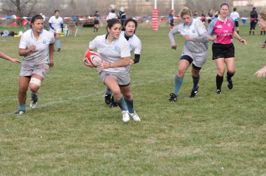 Player Running with the Ball in a Women's College Rugby Match clipart