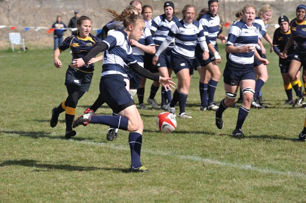 女性の大学ラグビーの試合でボールをキックする選手 — ストック写真