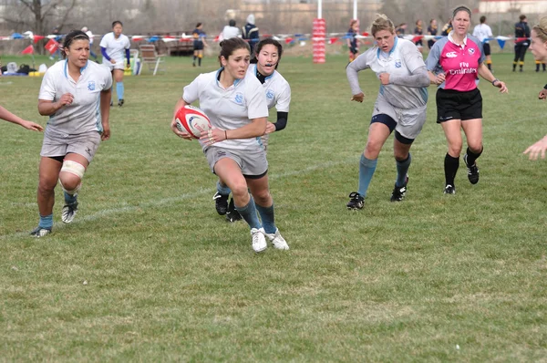 Jogador correndo com a bola em uma partida de rugby da faculdade feminina — Fotografia de Stock