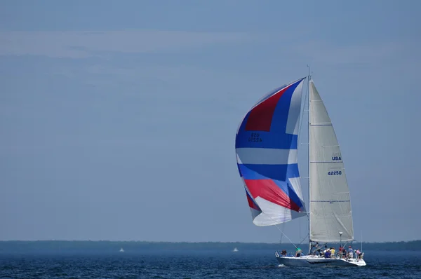 Segelboot mit buntem Spinakersegel segelt an einem Sommertag — Stockfoto