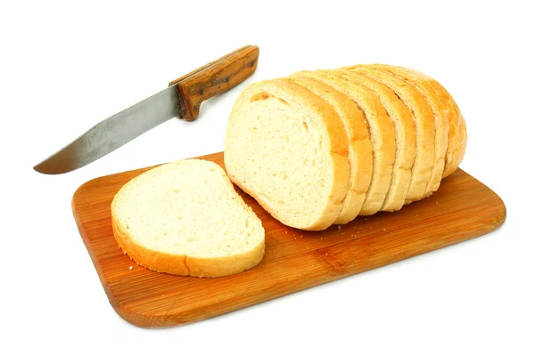 Нарезанный белый хлеб на деревянной доске — стоковое фото