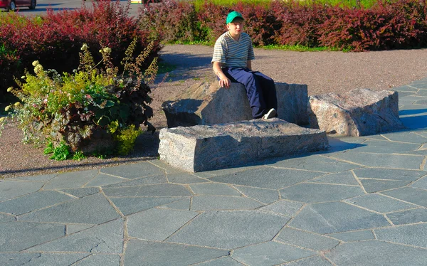 Le gars assis sur les rochers — Photo