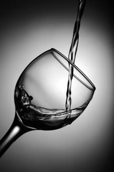 Vinho branco derramando em vidro — Fotografia de Stock